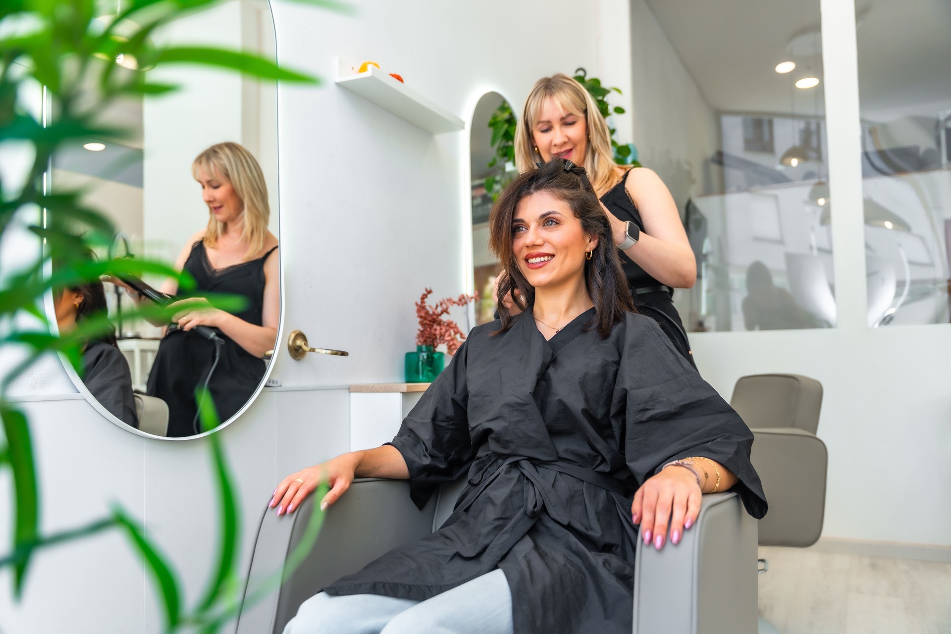 Hairdresser styling client's hair in modern beauty salon